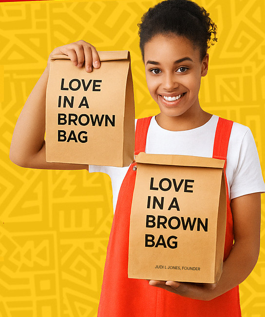 Volunteer holding Love in a Brown Bag meal bags